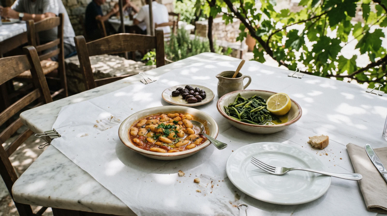 A taverna table of gigantes, dolmades, horta and olive oil, the naturally vegan and gluten-free side of Greek food in Athens, Greece