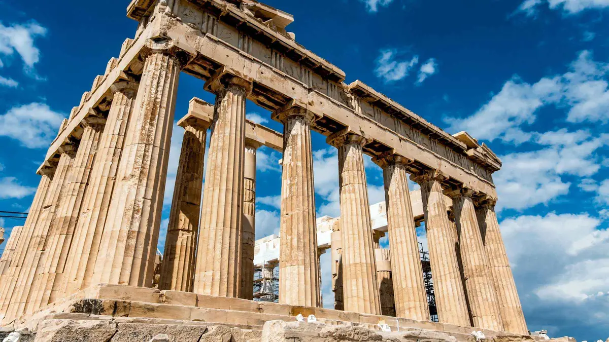 A phone showing an Acropolis e-ticket held up at the entrance gate in Athens, Greece