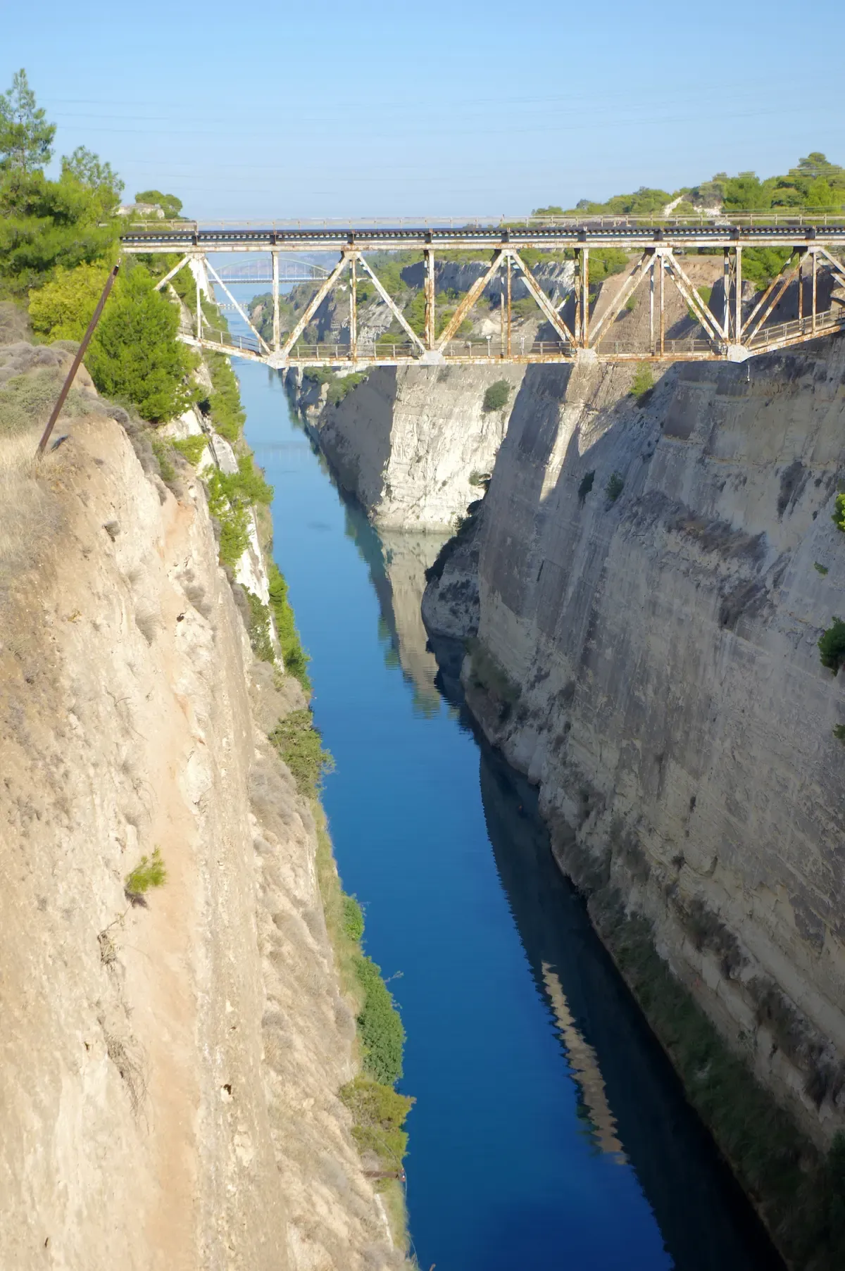 The Corinth Canal cut between vertical limestone walls, seen from the bridge on a day trip from Athens, Greece