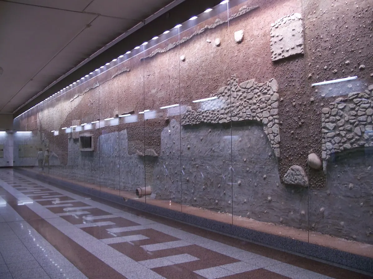 The excavation wall preserved behind glass on the platform at Syntagma metro station in Athens, Greece